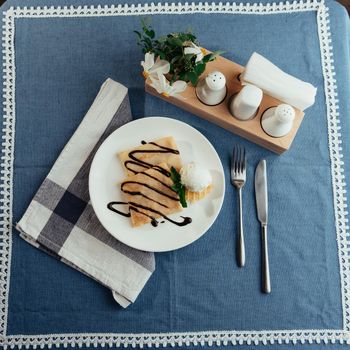 delicious pancakes with chocolate syrup and ice cream and a sprig of mint