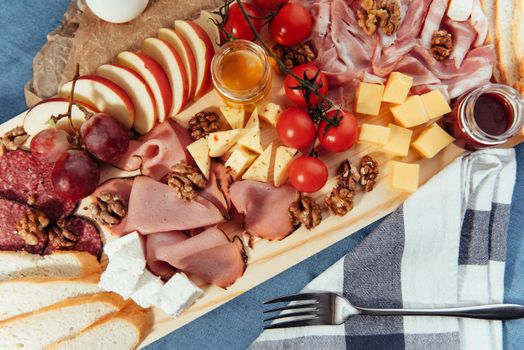 large wooden table meat, bread and vegetables.