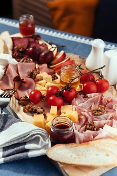 large wooden table meat, bread and vegetables.
