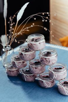 Blueberry dessert and fresh berries in a glass jar.