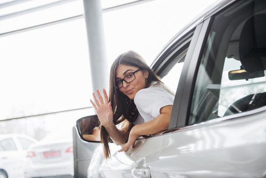 Pretty young woman driving her new car