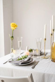 beautiful table setting for romantic dinner for two, with Linen napkins , yellow rose and boxwood. Close up