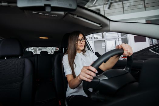 Pretty young woman driving her new car