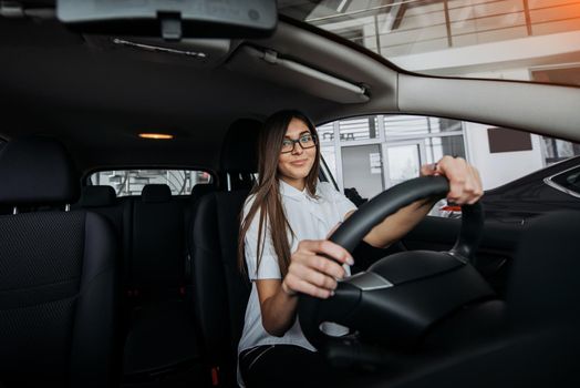 Pretty young woman driving her new car