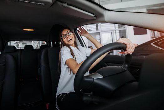 Pretty young woman driving her new car