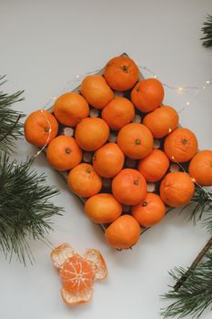 Christmas background with fir tree branches and tangerines. Merry Christmas and Happy New Year Greeting Card. Copy space. Top view. High quality photo