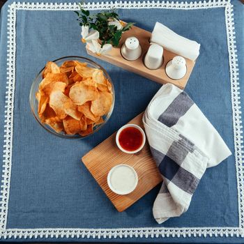 Potato chips with sauce on the table. Homemade sauces.