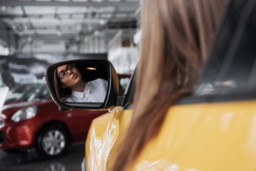 Young woman in her new car smiling.