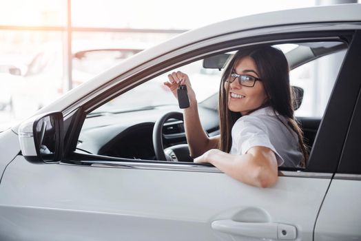 Young happy woman near the car with keys in hand - concept of buying car