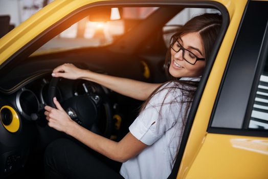 attractive young Caucasian woman looking at the camera from the front seat of the car