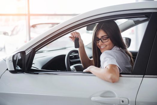 Young happy woman near the car with keys in hand - concept of buying car