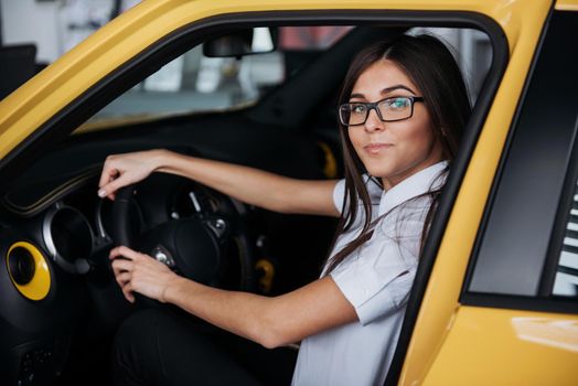 attractive young Caucasian woman looking at the camera from the front seat of the car