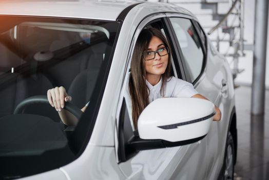 attractive young Caucasian woman looking at the camera from the front seat of the car