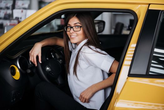 attractive young Caucasian woman looking at the camera from the front seat of the car