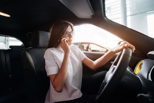 Businesswoman talking on the phone in the car.