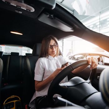 attractive young Caucasian woman looking at the camera from the front seat of the car