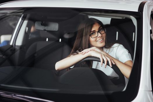 attractive young Caucasian woman looking at the camera from the front seat of the car