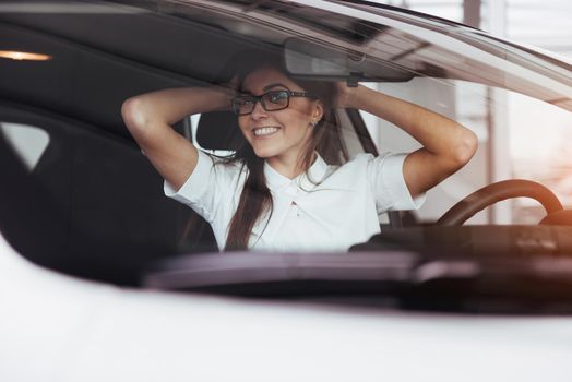 attractive young Caucasian woman looking at the camera from the front seat of the car