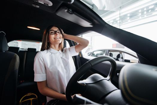 attractive young Caucasian woman looking at the camera from the front seat of the car