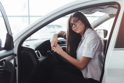 attractive young Caucasian woman looking at the camera from the front seat of the car