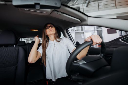 Pretty young woman driving her new car