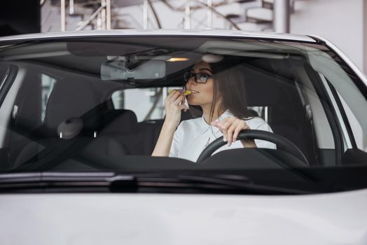 Pretty young woman driving her new car