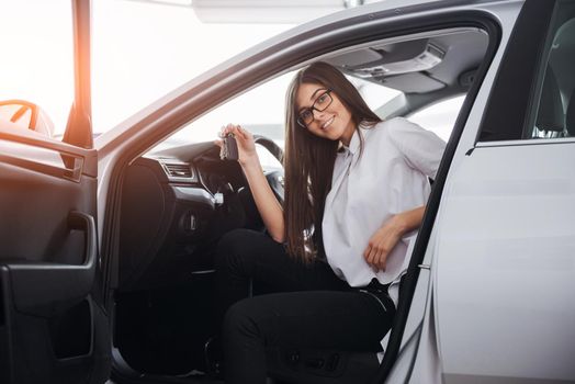 Young happy woman near the car with keys in hand - concept of buying car