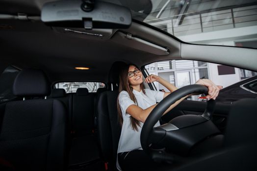 Pretty young woman driving her new car