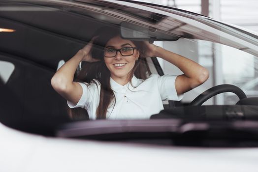 attractive young Caucasian woman looking at the camera from the front seat of the car