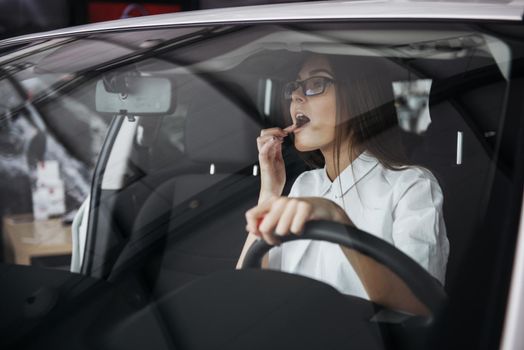 Pretty young woman driving her new car