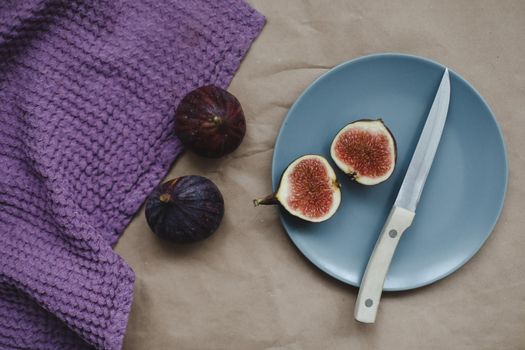 still life with ripe fresh figs and purple textiles on rustic background, flatlay, overhead view