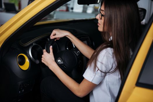 attractive young Caucasian woman looking at the camera from the front seat of the car