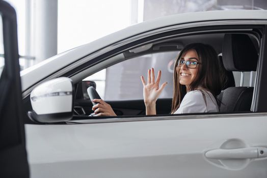 attractive young Caucasian woman looking at the camera from the front seat of the car