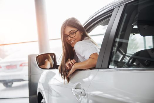 Pretty young woman driving her new car