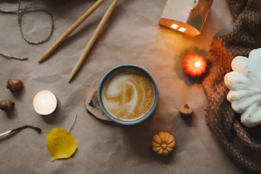 Autumn still life details in cozy home interior with a cup, candles, plaid. Hygge home decor. Halloween and Thanksgiving concept. Autumn banner
