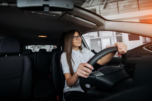 Pretty young woman driving her new car