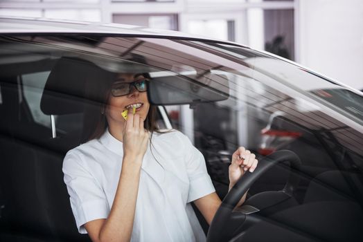 Pretty young woman driving her new car