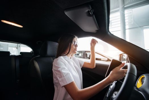 attractive young Caucasian woman looking at the camera from the front seat of the car