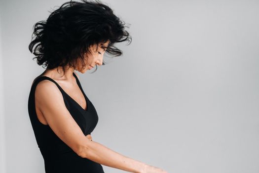 A woman in black sportswear is engaged in dynamic kali meditation in the Yoga hall.