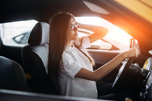 attractive young Caucasian woman looking at the camera from the front seat of the car