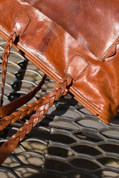 close-up photo of orange leather bag on a metal texture background. outdoor photo