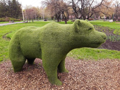 Decorative sculpture of a bear in a city park close-up.