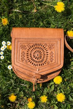 small yellow women's leather bag with a carved pattern. street photo