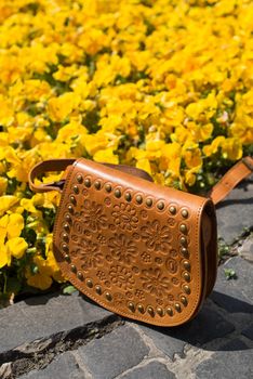 small yellow women's leather bag with a carved pattern. street photo