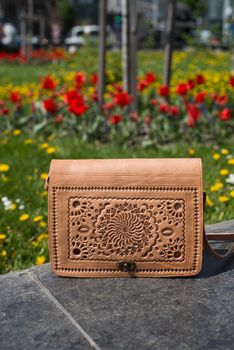 small yellow women's leather bag with a carved pattern. street photo