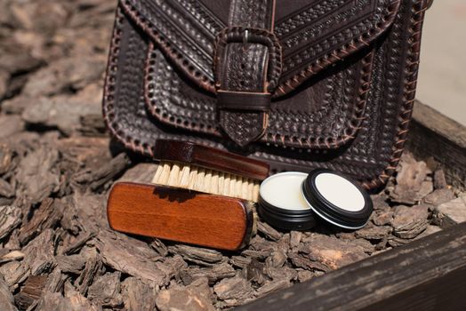 Wax and brush, leather maintenance concept. old genuine leather bag on a background. .