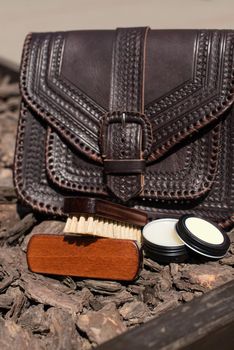 Wax and brush, leather maintenance concept. old genuine leather bag on a background. .