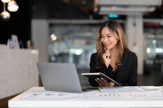 Young business asian woman working on laptop in office for accounting financial concept.