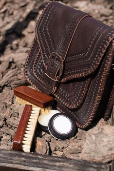 Wax and brush, leather maintenance concept. old genuine leather bag on a background. .