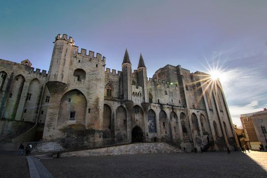 Palace of the Popes facade and the sun shining in a corner in Avignon in France